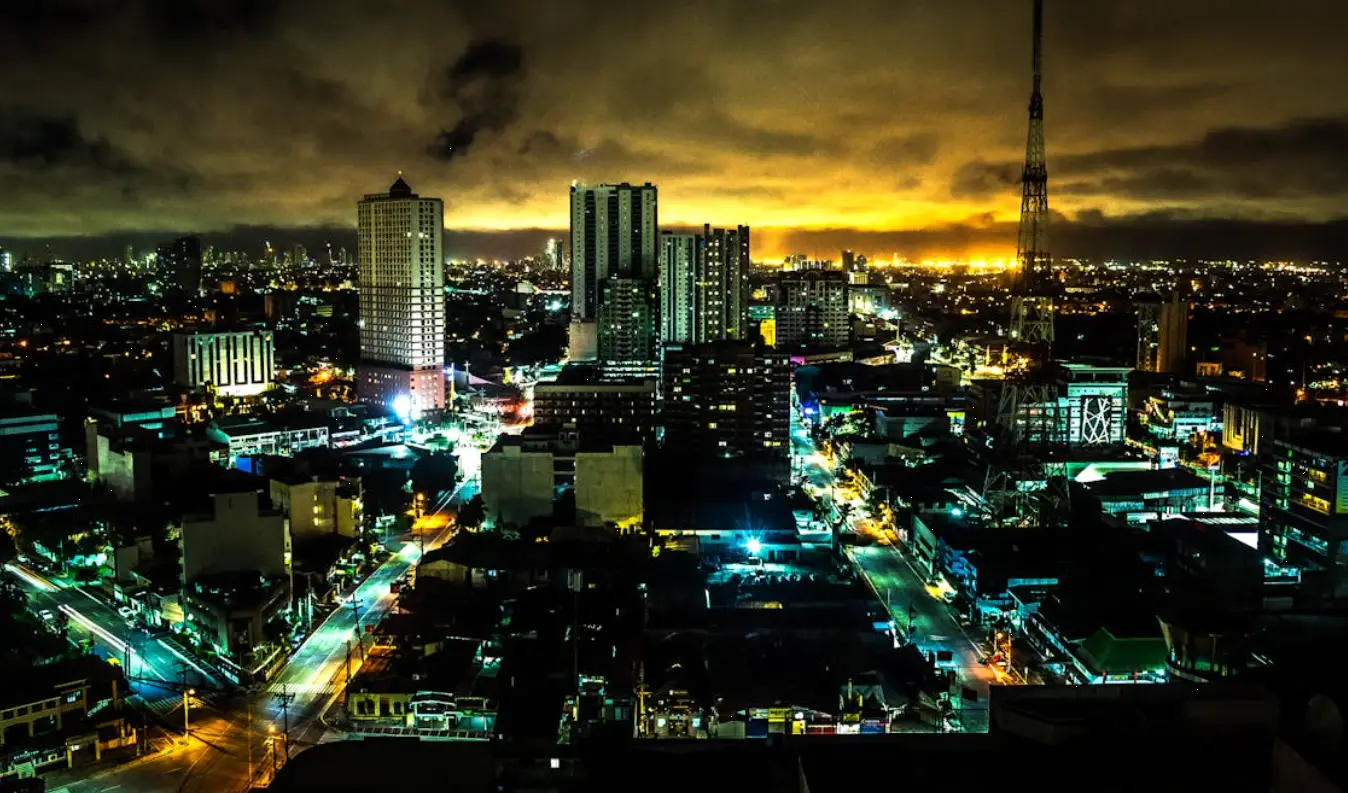 Aerial view of a city skyline at night with illuminated skyscrapers